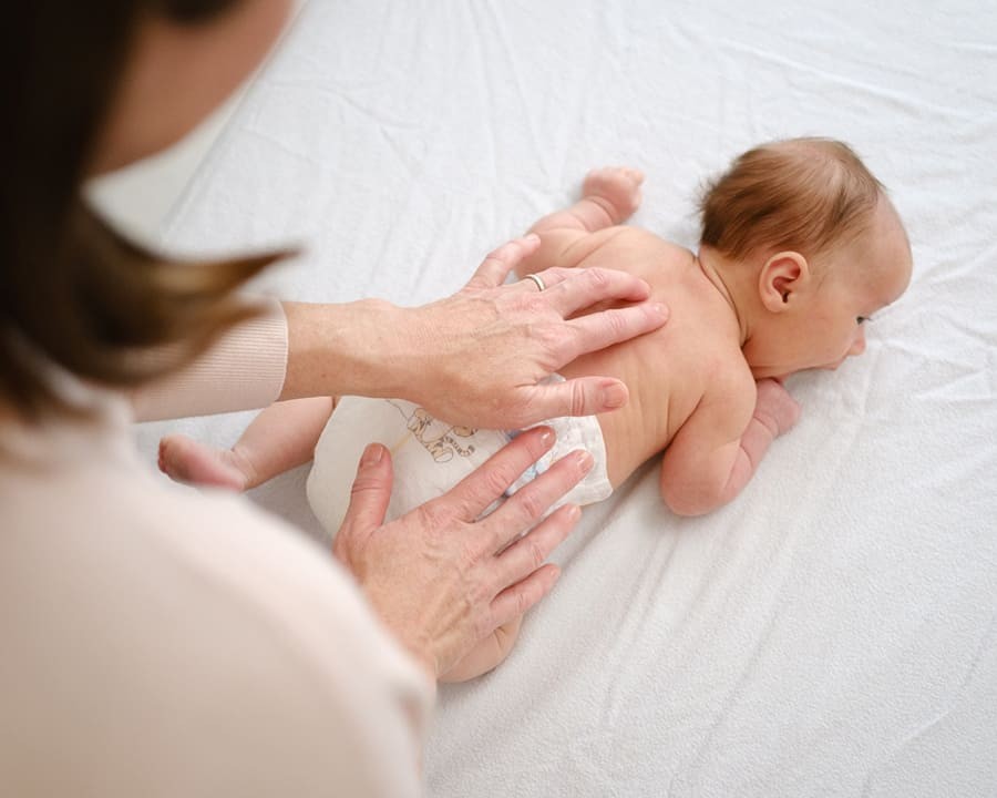 Pediatric osteopath providing gentle manual therapy for infant